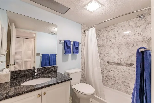 a bathroom with a granite countertop sink toilet and shower