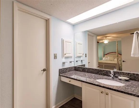 a bathroom with a granite countertop sink and a mirror