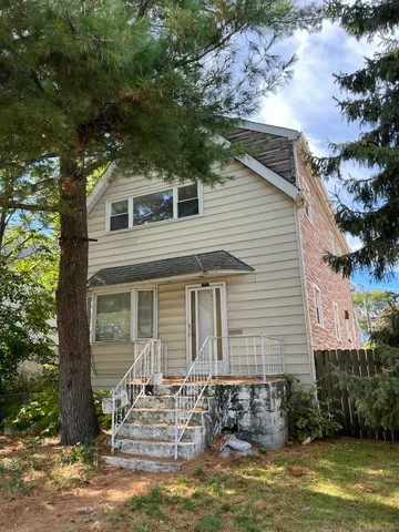 a front view of a house with a yard garage and outdoor seating