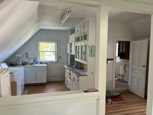 a kitchen with cabinets and wooden floor