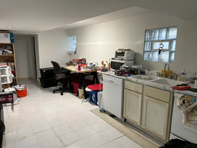 a view of a workspace with furniture and a window