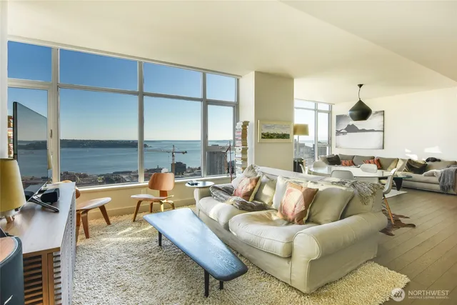 a living room with furniture wooden floor and a large window