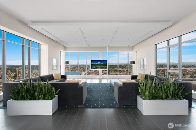 a living room with large windows and a table