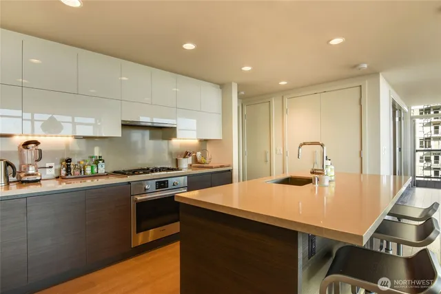a kitchen with stainless steel appliances granite countertop a sink a stove and a refrigerator