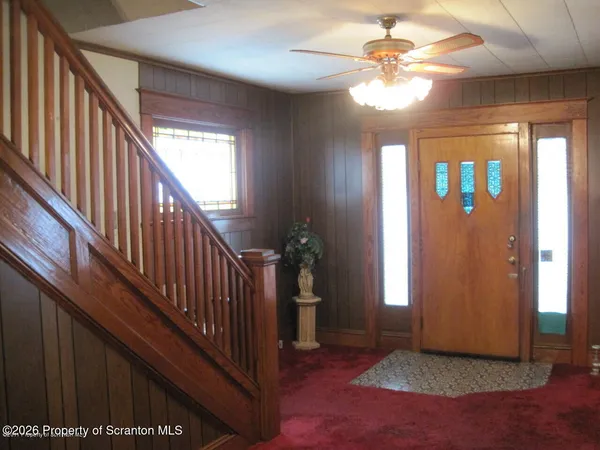 a view of staircase with railing and a chandelier