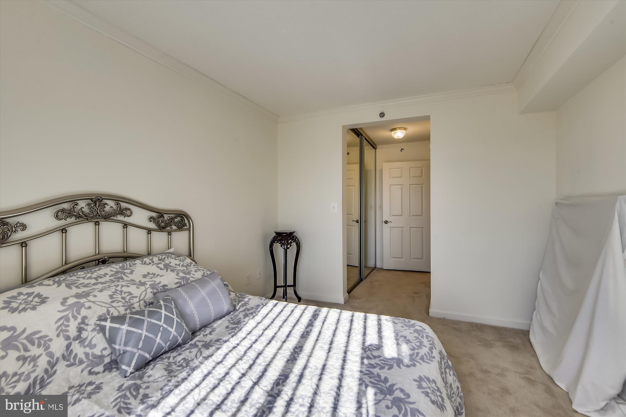 19385 Cypress Ridge Terrace, Unit 920 Leesburg, VA 20176 - Photo 18 of 42 a bedroom with a bed and a mirror