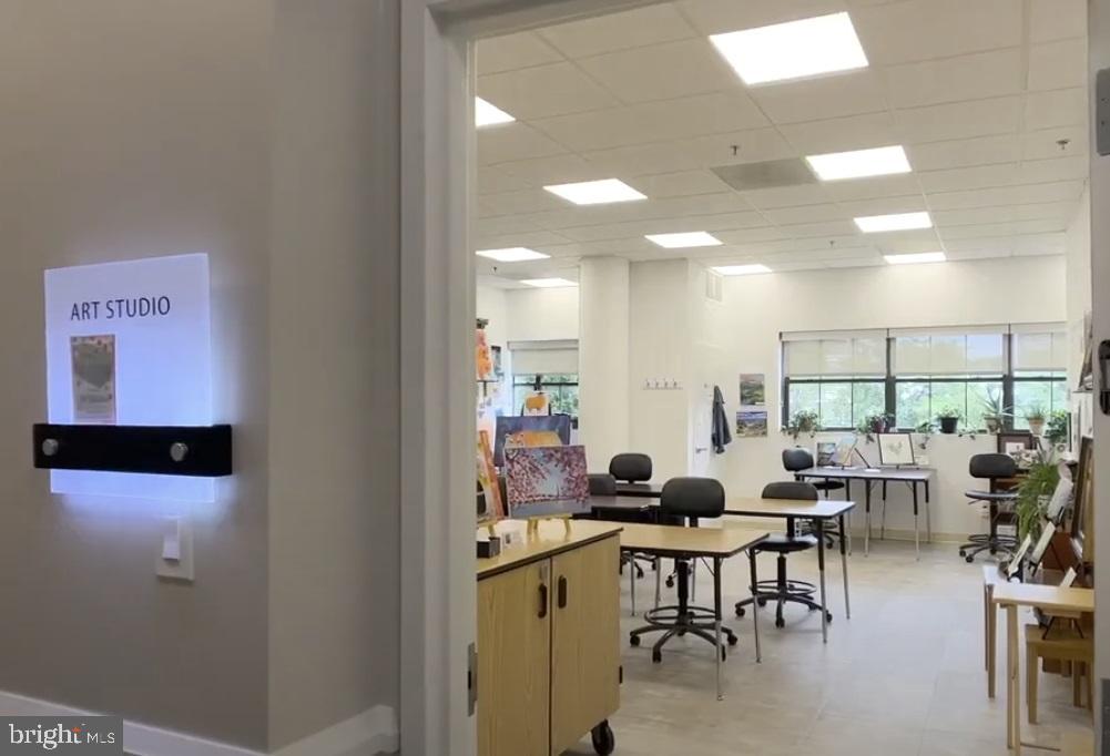 19385 Cypress Ridge Terrace, Unit 920 Leesburg, VA 20176 - Photo 30 of 42 a room with lots of tables a large window and chairs