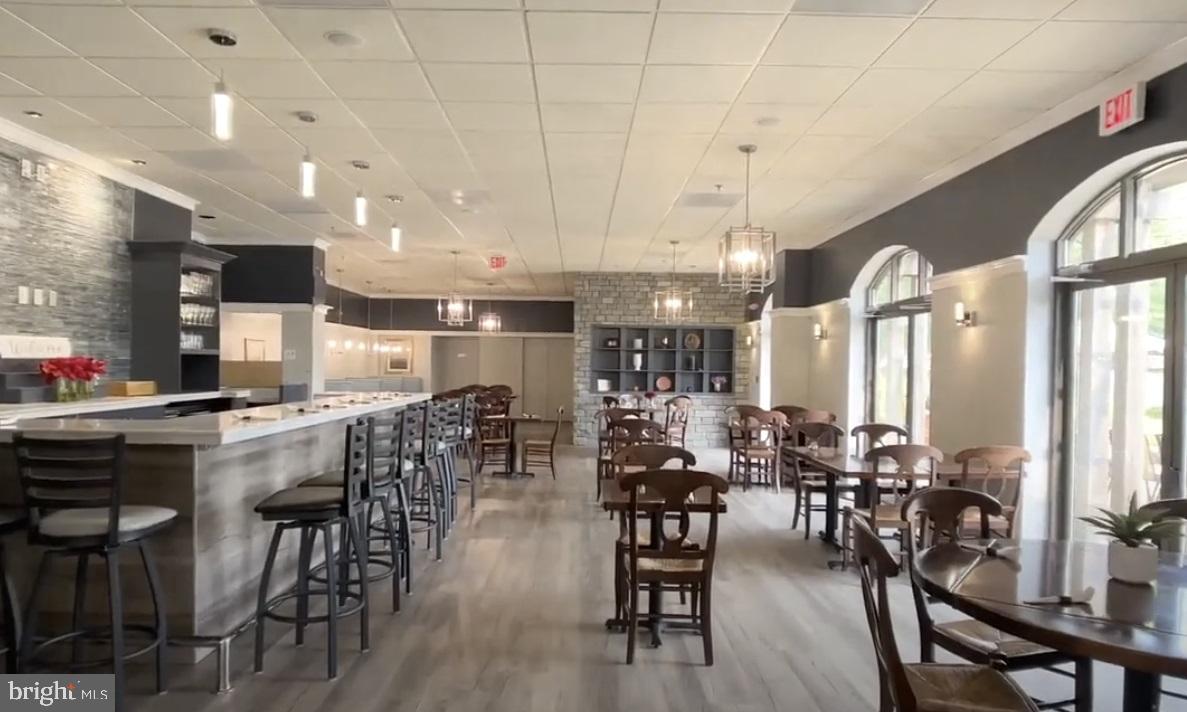 19385 Cypress Ridge Terrace, Unit 920 Leesburg, VA 20176 - Photo 39 of 42 a room with lots of wooden furniture a large window and stainless steel appliances