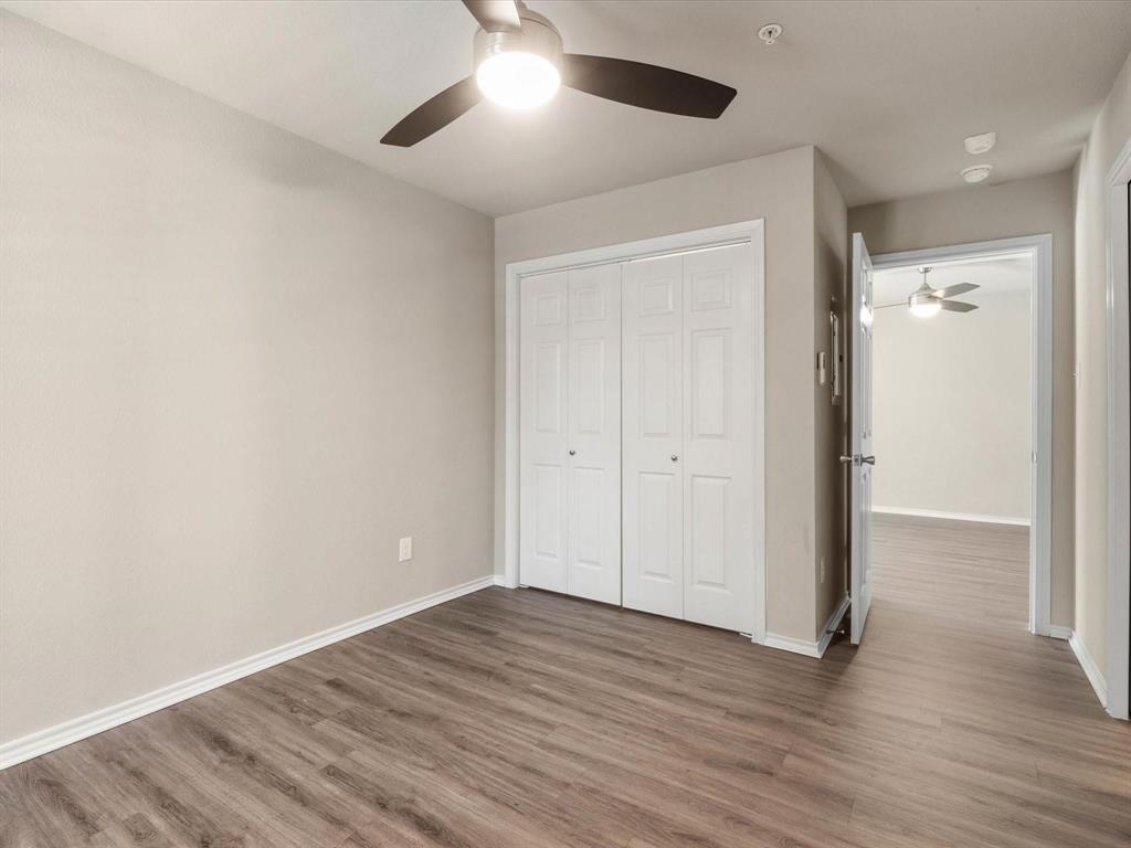 6108 Abrams Road, Unit 505 Dallas, TX 75231 - Photo 14 of 20 an empty room with wooden floor and windows