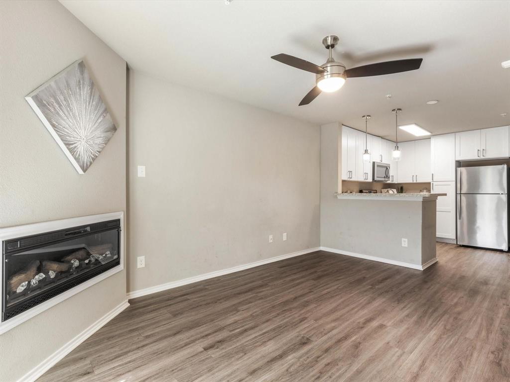 6108 Abrams Road, Unit 505 Dallas, TX 75231 - Photo 5 of 20 a view of a kitchen with a refrigerator a stove top oven cabinets and wooden floor