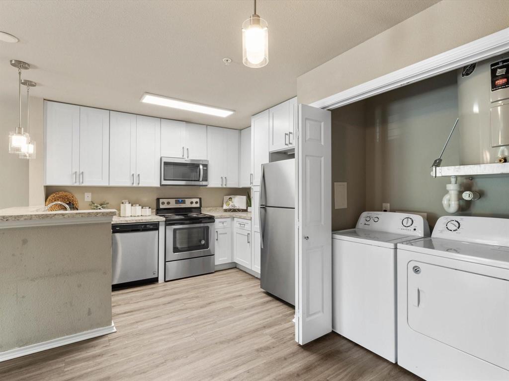 6108 Abrams Road, Unit 505 Dallas, TX 75231 - Photo 7 of 20 a kitchen with a refrigerator stove and wooden cabinets