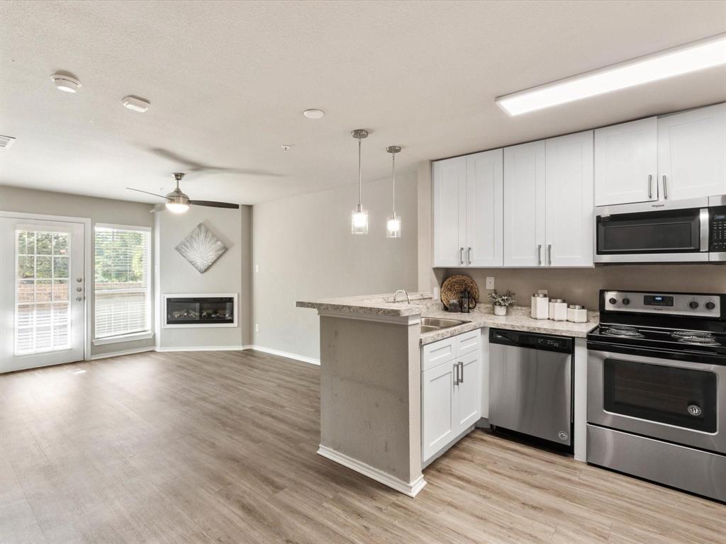 6108 Abrams Road, Unit 505 Dallas, TX 75231 - Photo 8 of 20 a kitchen with granite countertop a stove top oven and cabinets