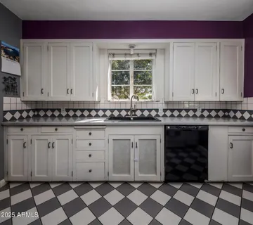 a view of a kitchen with granite countertop white cabinets and black appliances