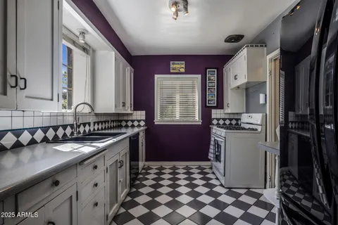 a kitchen with a sink a refrigerator and cabinets