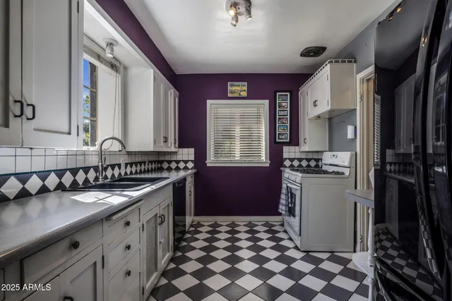 a kitchen with a sink a refrigerator and cabinets