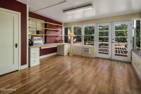 a room with wooden floors and windows