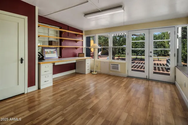 a room with wooden floors and windows