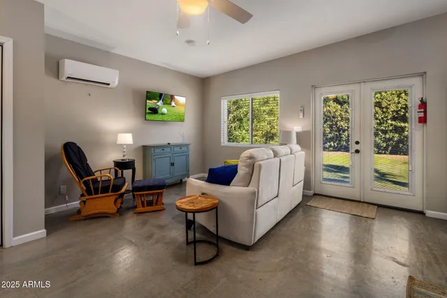 a living room with stainless steel appliances furniture and a kitchen view