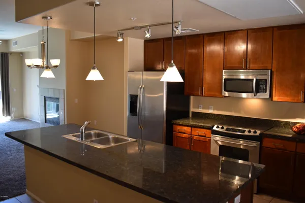 a kitchen with stainless steel appliances granite countertop a sink a stove and a refrigerator