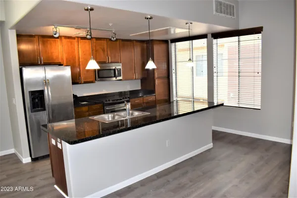 a kitchen with granite countertop a refrigerator and a sink