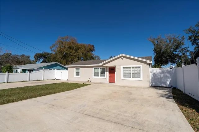 a view of house with a yard and large trees
