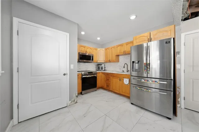 a kitchen with stainless steel appliances a refrigerator sink and microwave