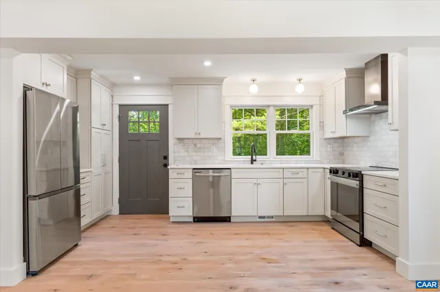 a kitchen with white cabinets and white appliances