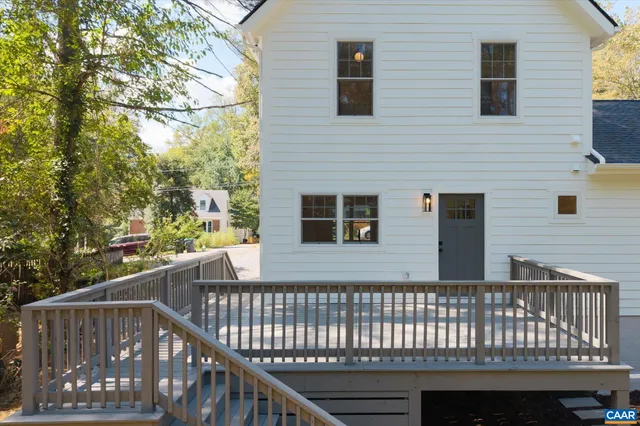 a view of an empty room with wooden floor and stairs