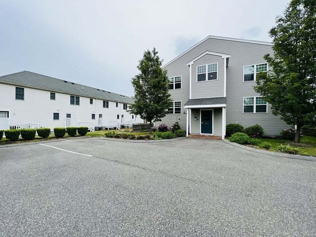 39 Athens Street, Unit 1 Weymouth, MA 02191 - Photo 2 of 13 a front view of a house with a yard and garage