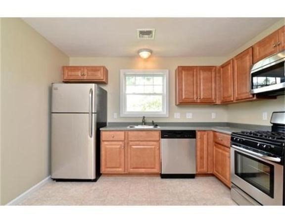 39 Athens Street, Unit 1 Weymouth, MA 02191 - Photo 6 of 13 a kitchen with stainless steel appliances granite countertop a refrigerator a stove a sink and a microwave
