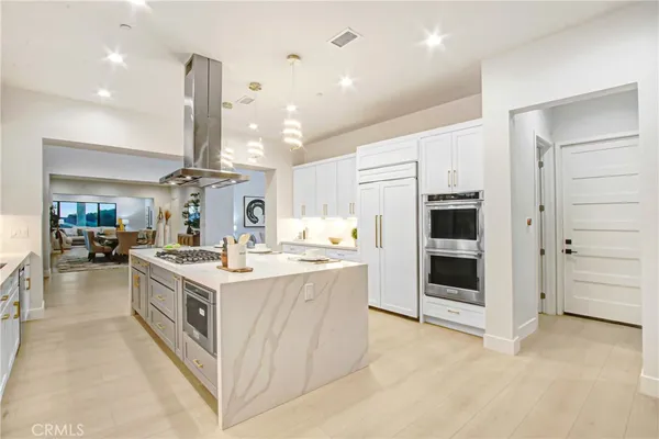 a large kitchen with stainless steel appliances a stove and more cabinets