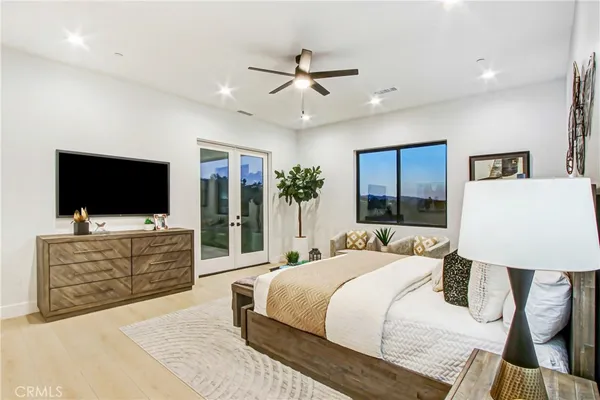 a spacious bedroom with a large bed and a chandelier