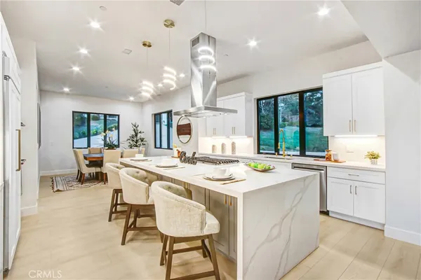 a kitchen with a sink a stove a dining table and chairs