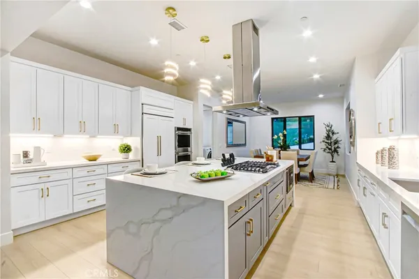 a kitchen that has a lot of cabinets a sink and wooden floor