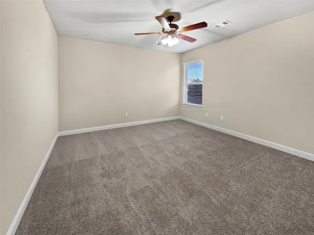 an empty room with windows and fan