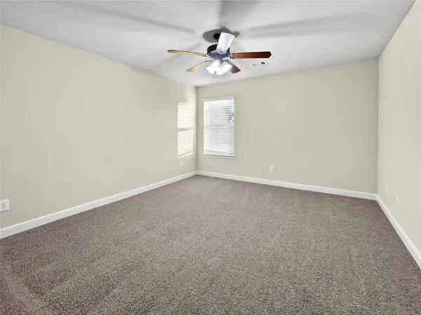 a view of an empty room with a ceiling fan
