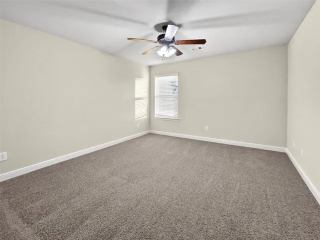 a view of an empty room with a ceiling fan
