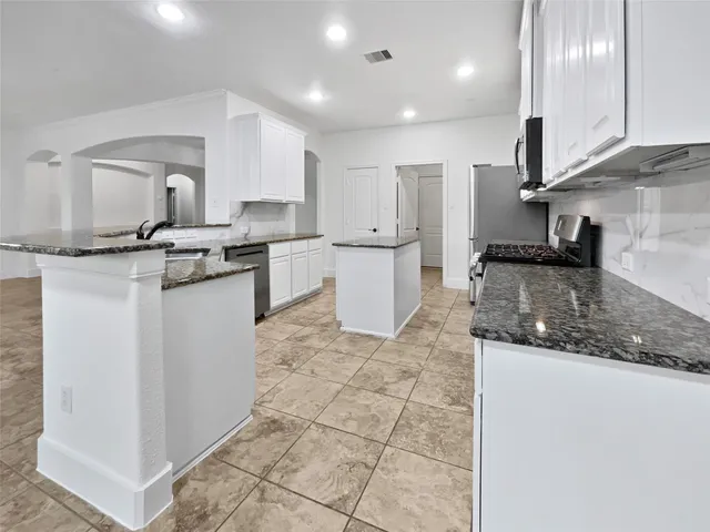 a kitchen with a sink a counter top space appliances and cabinets