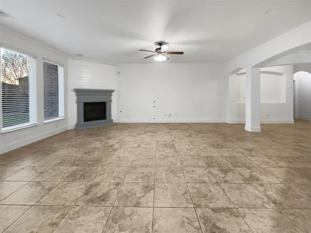 en empty room with windows and fireplace