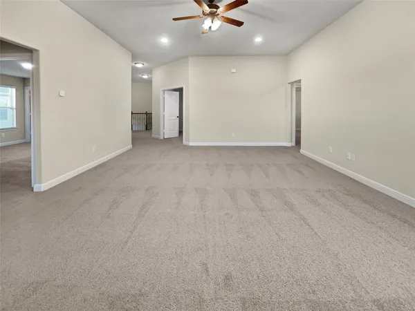 an empty room with a ceiling fan and a window