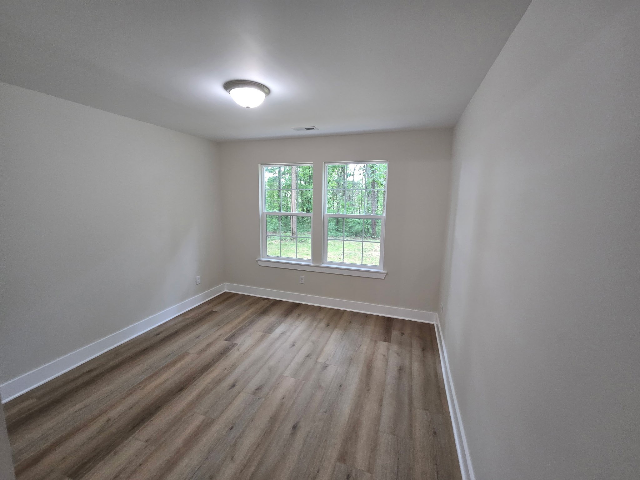 841 Lucas Road Dickson, TN 37055 - Photo 17 of 21 an empty room with wooden floor and windows