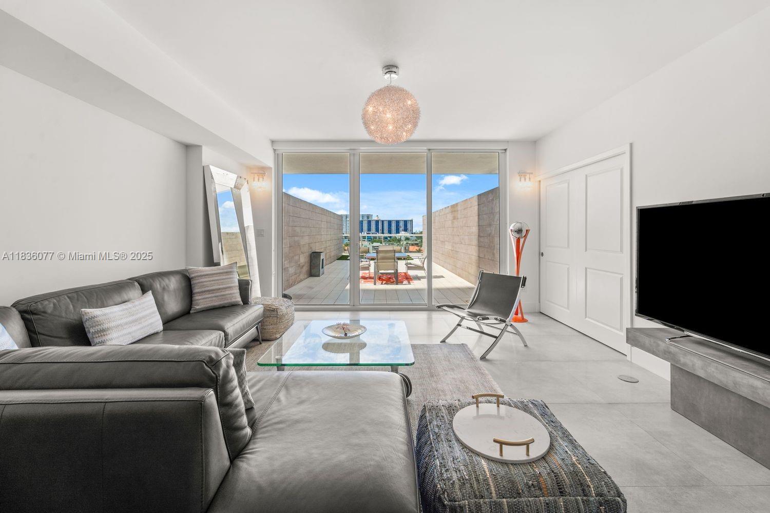 400 Sunny Isles Boulevard, Unit 616 Sunny Isles Beach, FL 33160 - Photo 2 of 19 a living room with furniture a flat screen tv and a window