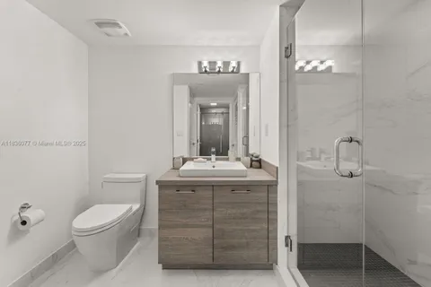 a bathroom with a toilet a sink and mirror