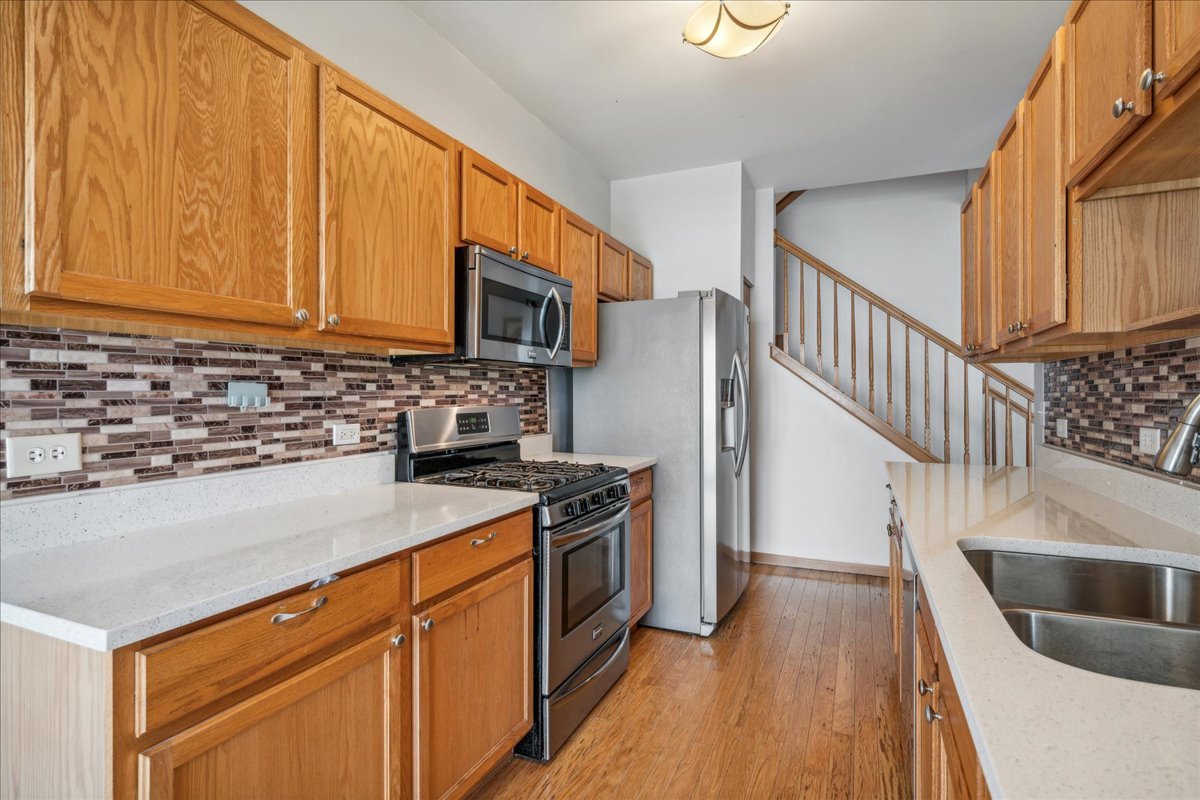 746 County Line Road Aurora, IL 60502 - Photo 8 of 16 a kitchen with granite countertop a sink a stove top oven and cabinetry