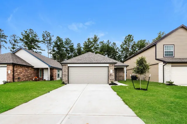 a front view of a house with a yard and trees