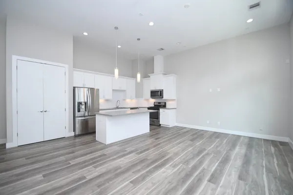 a large kitchen with a lot of counter space and stainless steel appliances