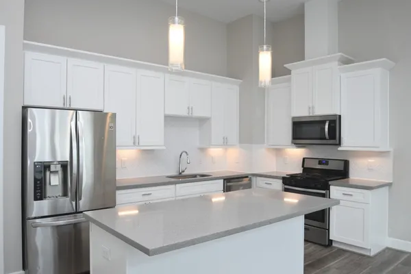 a kitchen with refrigerator and white cabinets