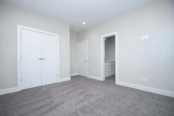 an empty room with closet and a hallway