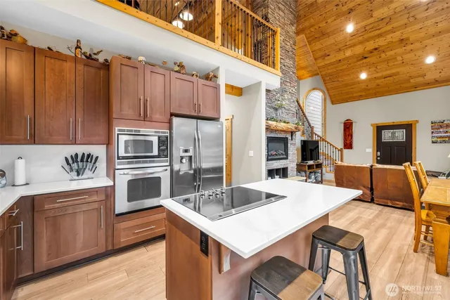 a kitchen that has a kitchen island a sink a stove and chairs
