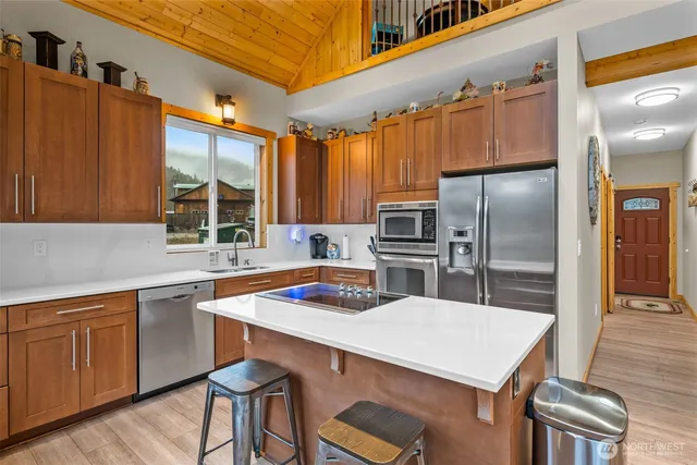 a kitchen with cabinets a counter space stainless steel appliances and cabinets